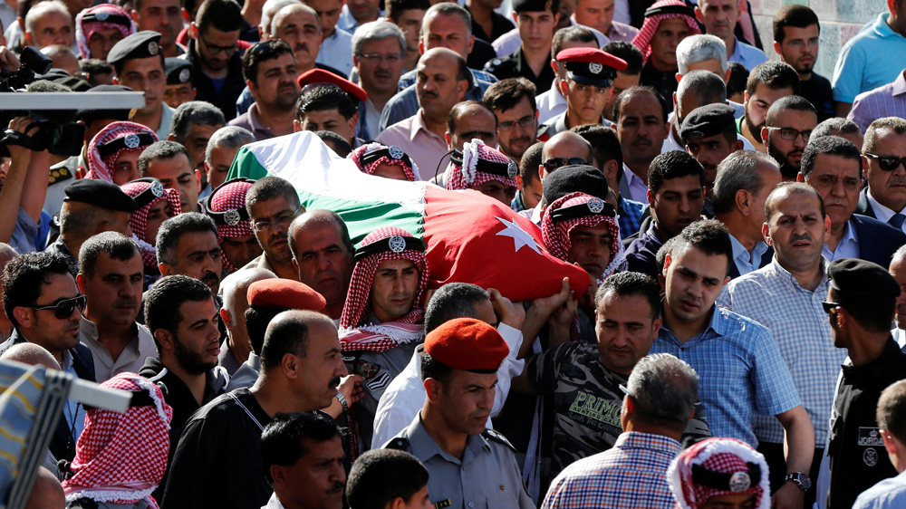 Jordanian soldiers and relatives of one of the intelligence officers killed carry his body during his funeral [Muhammad Hamed/Reuters]