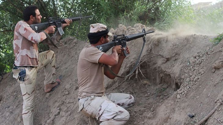 Iraqi pro-governement forces fire their weapons on a front line in the Albu Huwa area, south of Fallujah