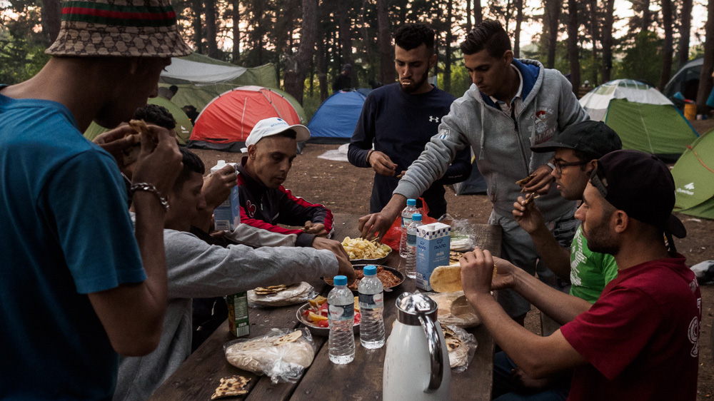 Muslim refugees celebrate Iftar, or the breaking of their fast, in the forest in Evzoni, Greece [Lazar Simeonov/Al Jazeera]