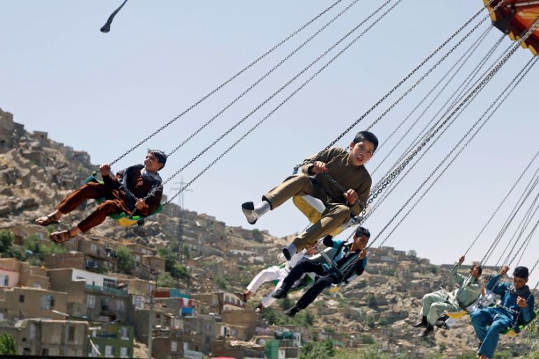 Afghan youths ride on swings during the first day of the Muslim holiday of Eid al-Fitr, which marks the end of the holy month of Ramadan, in Kabul, Afghanistan [REUTERS]