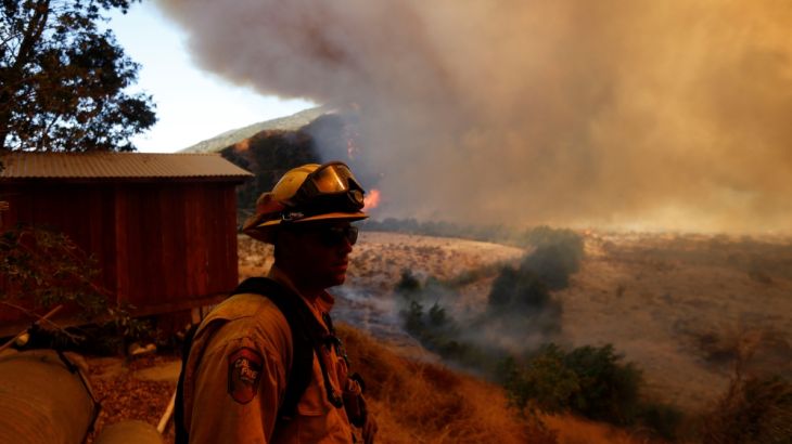 Firefighters protect homes during the Blue Cut Fire in San Bernardino County, California