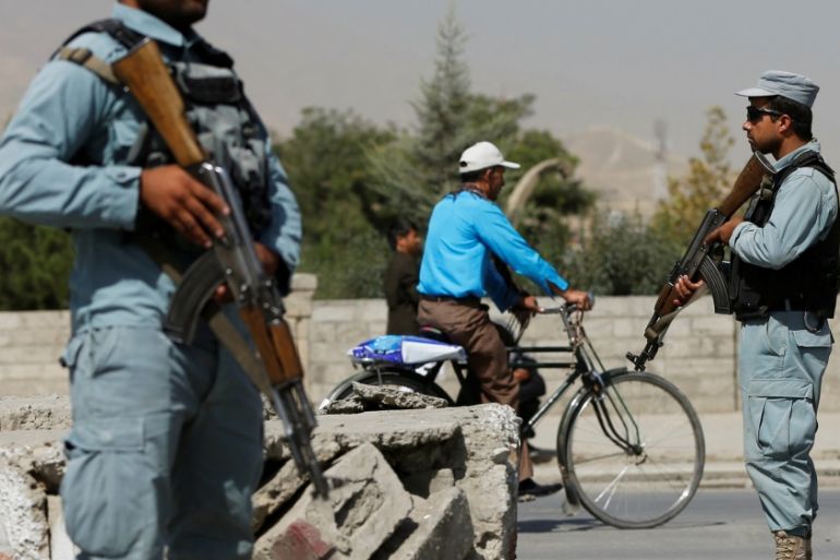 Afghan policemen stand guard at a checkpoint near the site of kidnapping in Kabul,