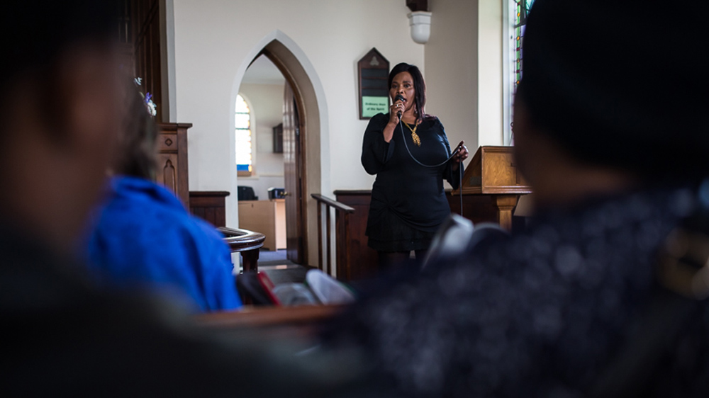 Elizabeth Gqoboka, a spokeswoman for Reclaim the City, addresses a gathering at Sea Point Methodist Church about the need for social housing in the area [Shaun Swingler/Al Jazeera]