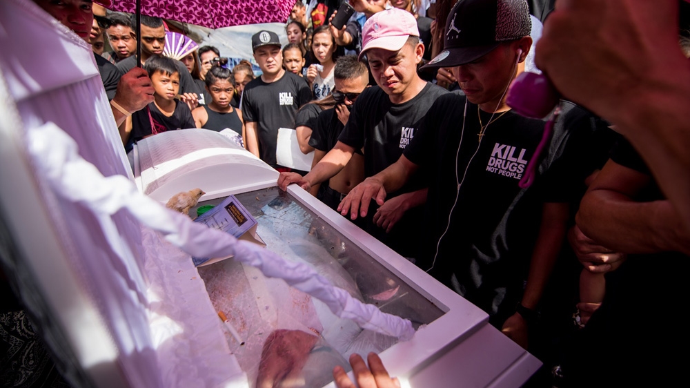 Family and friends of slain rickshaw driver Eric Sison give their last prayers and farewell [ Martin San Diego/Al Jazeera]