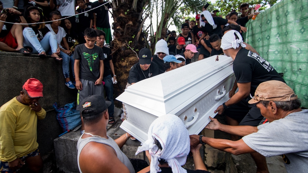 Family and friends of rickshaw driver Eric Sison, who was shot by police, help to carry his coffin [Martin San Diego/Al Jazeera]
