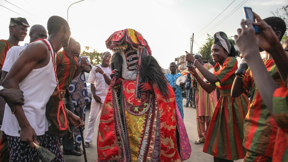 An Egungun masquerade dances in the street of the Brazilian quarter of Lagos, Nigeria [Chris Stein/Al Jazeera] 