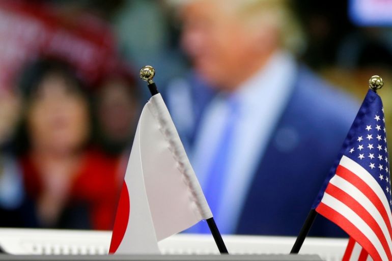 National flags of Japan and the U.S. are seen in front of a monitor displaying U.S. Republican presidential nominee Donald Trump on TV news at a foreign exchange trading company in Tokyo