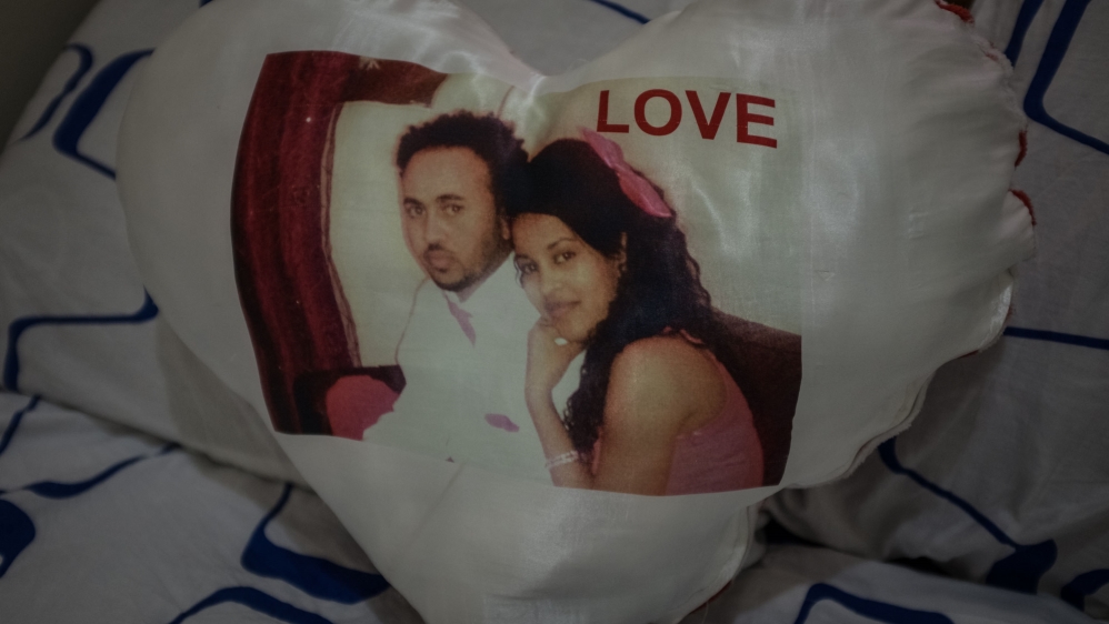 A printed, heart-shaped cushion features Eritrean asylum seekers Awat and Ksenet [Violeta Moura/Al Jazeera]