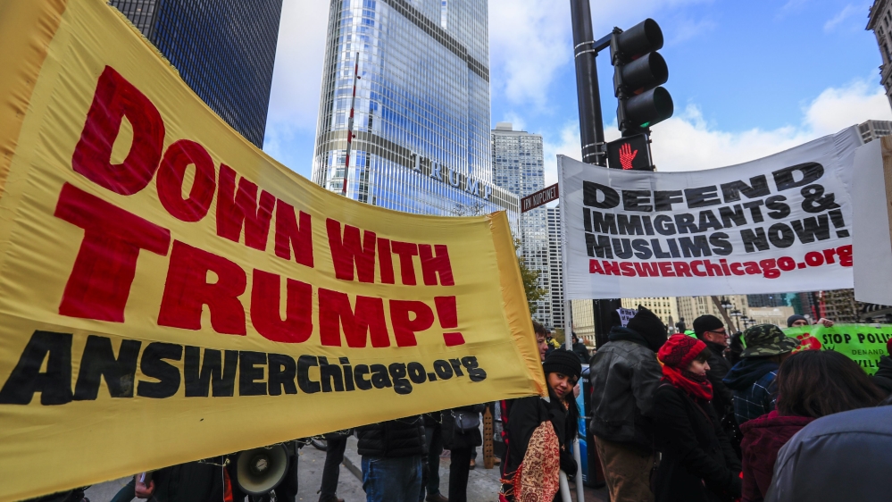 protesters bearing signs and banners take to the streets near Chicago's Trump Tower, showing their opposition to the election of Trump as president [EPA]