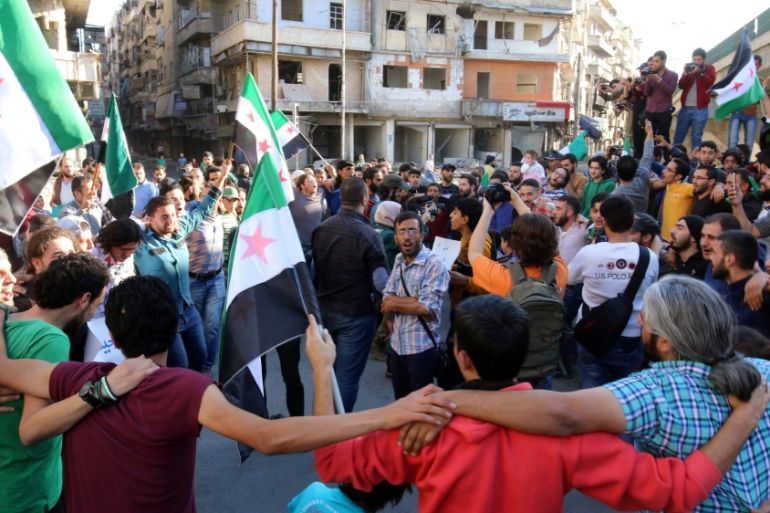 People carry Free Syrian Army flags while attending a protest against evacuating civilians out of Aleppo, in the rebel held besieged al-Shaar neighbourhood of Aleppo