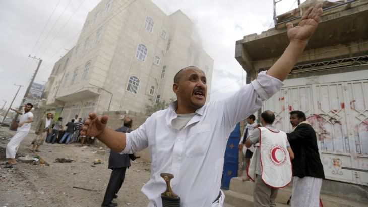 People react at the site of an airstrike in Sanaa