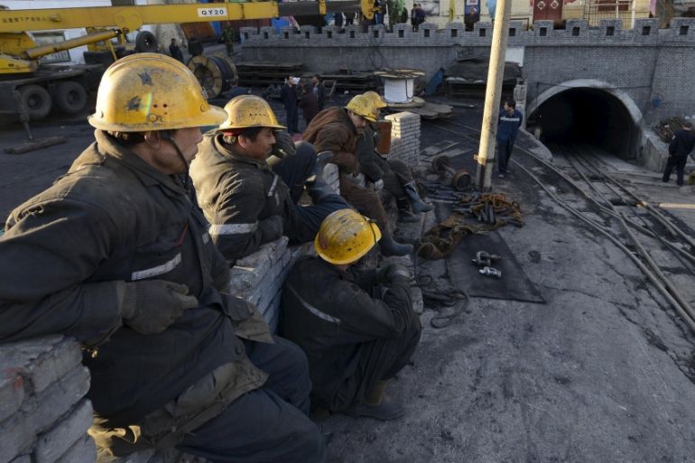 Rescuers sit next to the entrance of a coal mine after a flooding incident in Datong