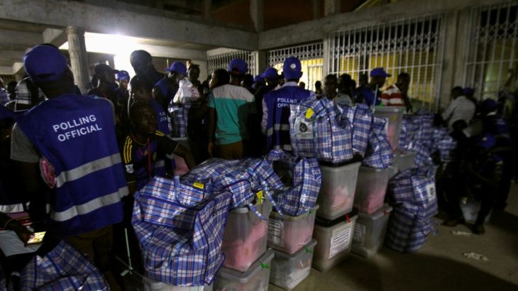 Polling agents stand next to ballot boxes at a collection center at the Odorkor police station in Accra, Ghana
