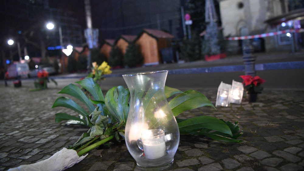 Flowers and candles are placed near the Kaiser Wilhelm Memorial Church in Berlin after a lorry ran into a crowded Christmas market [Britta Pedersen/AP]