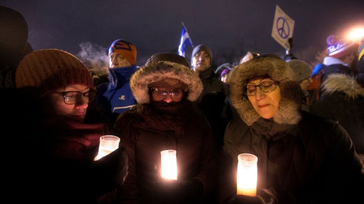 People hold candles as they attend a vigil in honour of the victims of a shooting in a Quebec mosque in Quebec City, Quebec