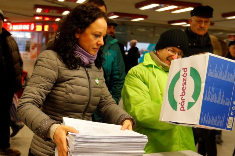 hands over documents with signatures supporting a referendum on Budapest?s 2024 Olympic bid to political movement Momentum at a stand in Budapest