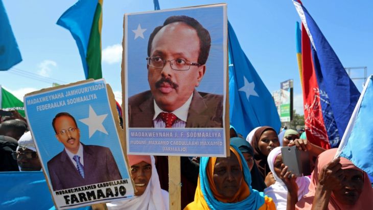 Women carry posters with the image of the newly elected Somalian President Mohamed Abdullahi Mohamed as they celebrate his victory, near the Daljirka Dahson monument in Mogadishu