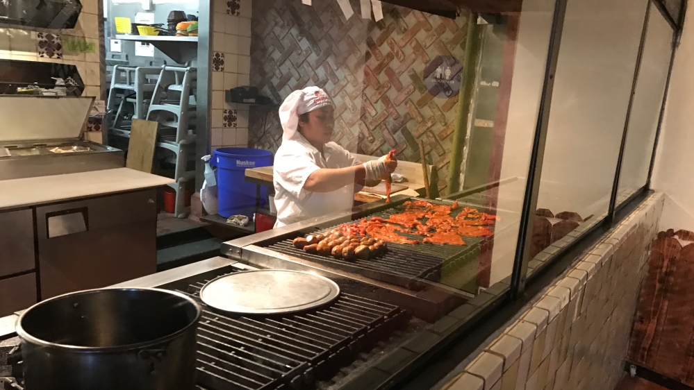 A chef prepares meat at Guelaguetza Oaxacan-style Mexican restaurant in Koreatown Los Angeles. [Massoud Hayoun/Al Jazeera]