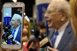 Berkshire Hathaway CEO Warren Buffett is seen on a cellphone camera as he talks to reporters prior to the Berkshire annual meeting in Omaha