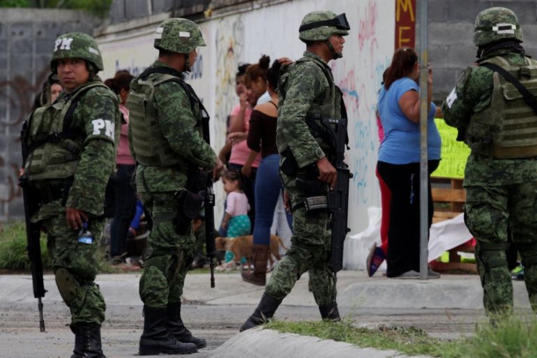 Soldiers patrol the perimeter of a crime scene where police found trash bags with human remains in the back of an abandoned pick-up truck, according to local media, in Monterrey