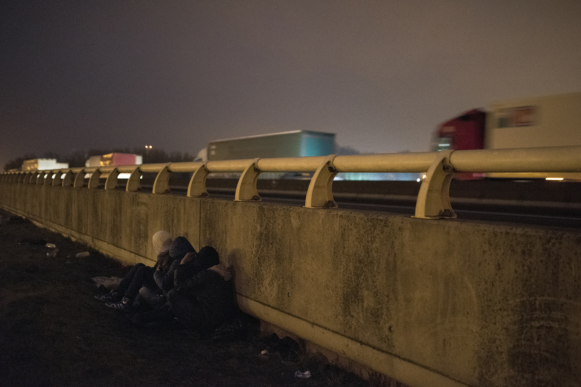 Young Eritrean and Oromo Ethiopian refugees wait next to a motorway close to a truck stop [Guillem Trius/Al Jazeera]