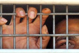 A Palestinian prisoner is seen behind bars as he is brought into the Hadariam prison, north of Tel Aviv [File: Tsafrir Abayov/The Associated Press]