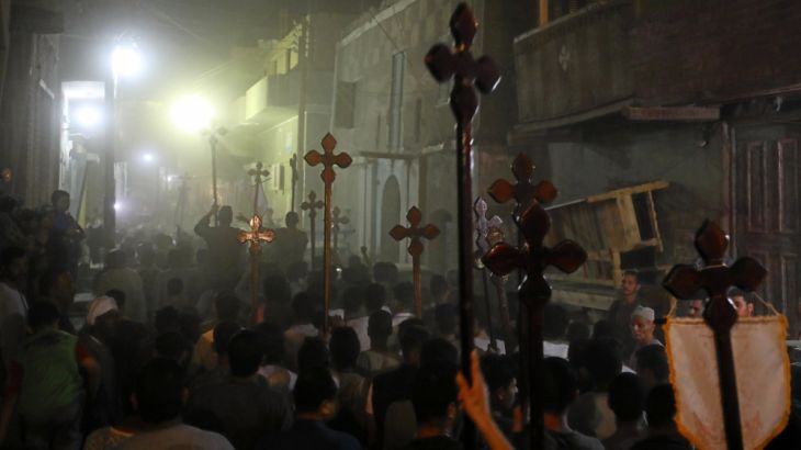 Mourners carry crosses and march after the funeral of Coptic Christians who were killed on Friday in Minya