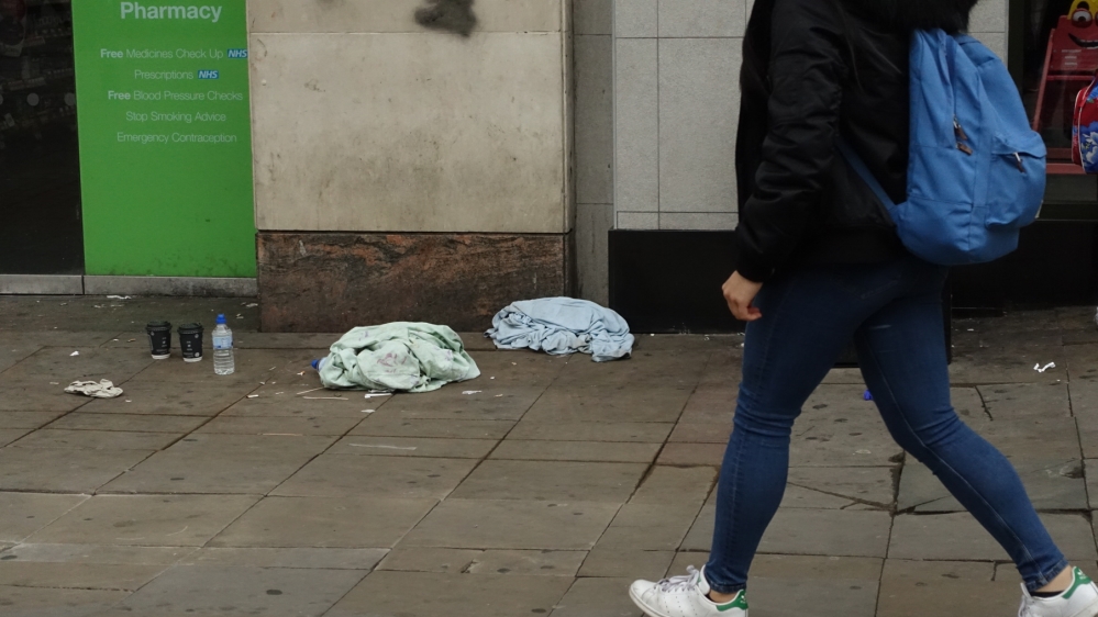Blankets and cups of tea left by rough sleepers in Manchester city centre [Shafik Mandhai/Al Jazeera] 