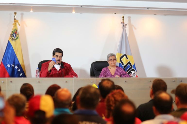 Venezuela''s President Nicolas Maduro holds a copy of the Venezuelan constitution as he speaks next to CNE President Tibisay Lucena during their meeting in Caracas