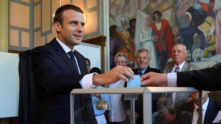 French President Emmanuel Macron casts his ballot as he votes at a polling station in the second round parliamentary elections in Le Touquet