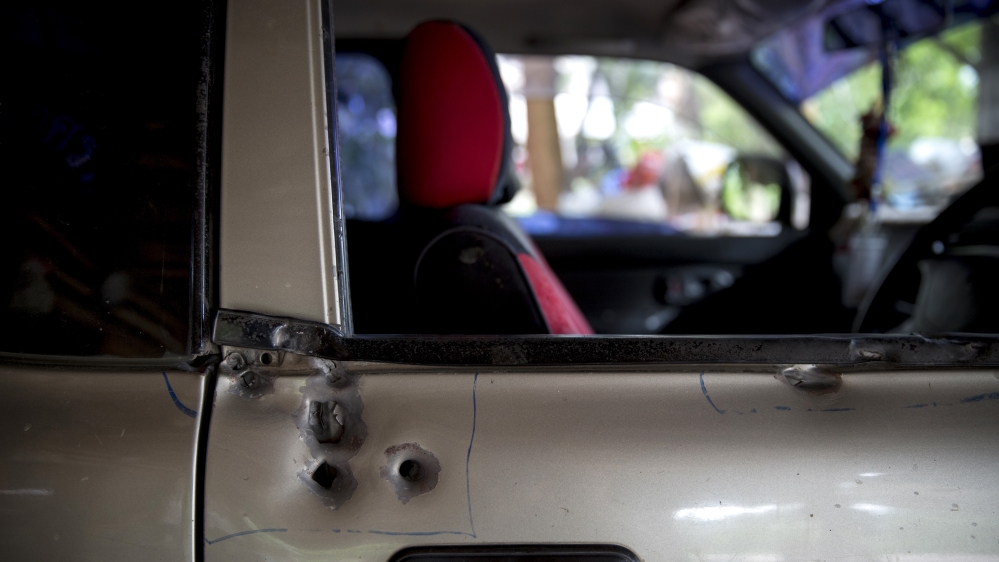 Supot Kalasong's car showing bullet holes after an attempt was made on his life [Al Jazeera]