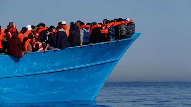 FILE PHOTO: Migrants on a wooden boat await rescue by the Malta-based NGO Migrant Offshore Aid Station (MOAS) in the central Mediterranean
