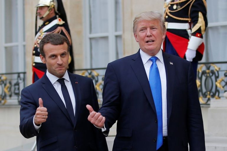 French President Emmanuel Macron and U.S. President Donald Trump react in the courtyard after a joint news conference at the Elysee Palace in Paris