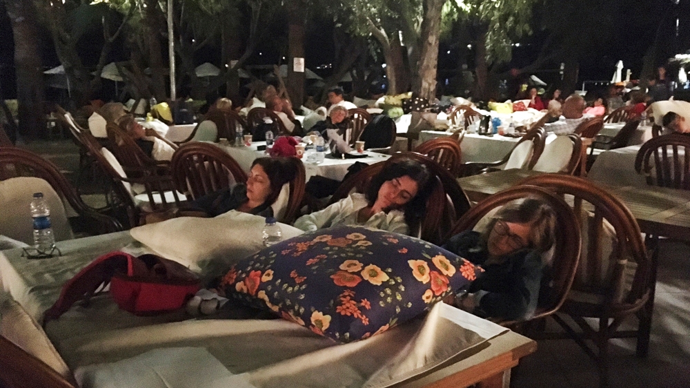 Hotel guests sleep outdoors after abandoning their rooms following an earthquake in Bitez, Turkey [Ayse Wieting/AP]