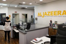 An employee walks inside an office of Qatar-based Al-Jazeera network in Jerusalem