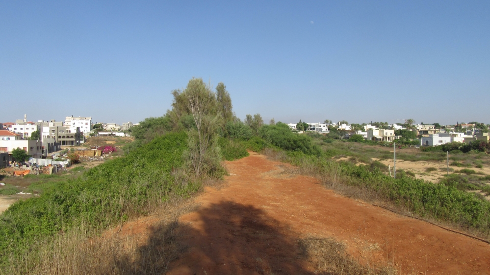 There is a land barrier between Jisr al-Zarqa, left, and Caesarea, one of the three Jewish towns surrounding the Arab village [Yuval Abraham/Al Jazeera] 