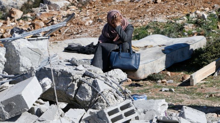 Palestinian woman reacts as she sits next to the rubble of her house after it was demolished by the Israeli army as it did not have an Israeli-issued construction permit, in the West Bank