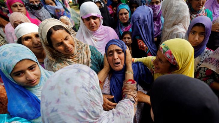 Women console a relative of Zahid Ahmad Bhat during his funeral prayers in Nawdal village in Pulwama district