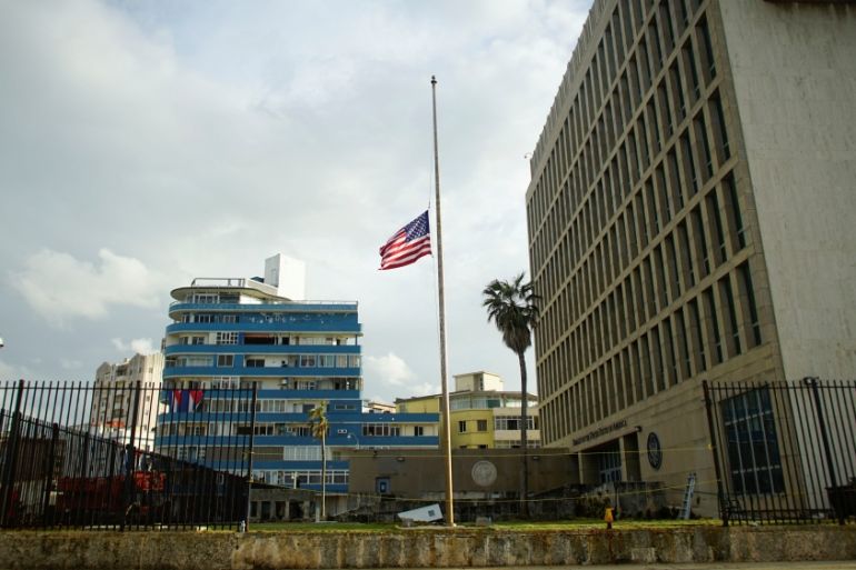 The U.S. flag is lowered to half mast in front of a damaged fence of the U.S. embassy after Hurricane Irma caused flooding and a blackout, in Havana