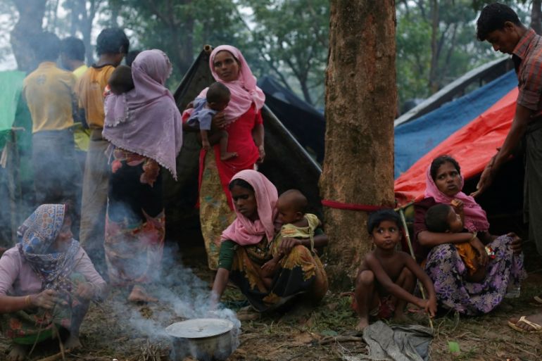 Rohingya refugees go about their day outside their temporary shelters along a road in Kutupalong, Bangladesh