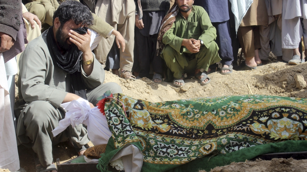 
Villagers mourn after a victim was killed during clashes between Taliban and Afghan security forces in the Taliban-controlled village of Buz-e Kandahari village in Kunduz province [File: Najim Rahim/AP]
