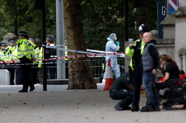 Police and forensic officers stand in the road near the Natural History Museum, after a car mounted the pavement, in London