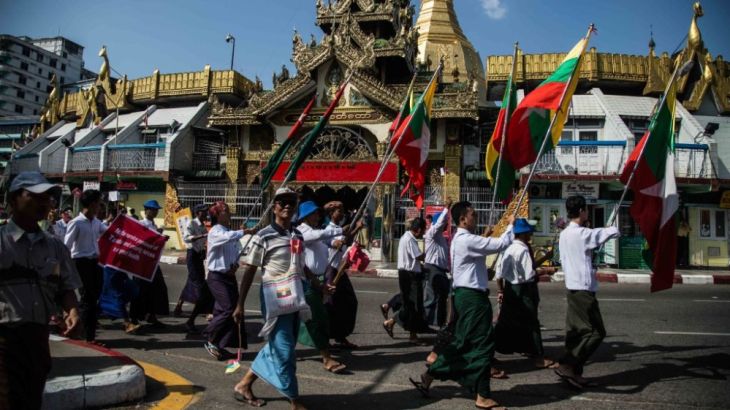 YANGON, BURMA - OCTOBER 29: Demonstrators march through downtown with Myanmar and Tatmadaw military flags on October 29, 2017 in Yangon, Burma. Thousands of Burmese rallied in Yangon in support of the