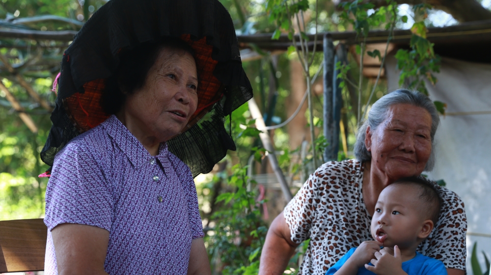 Hakka grandmother and grandson in Po Kat Tsai village in Fanling, New Territories [Amy Ip Ka Man/Al Jazeera]