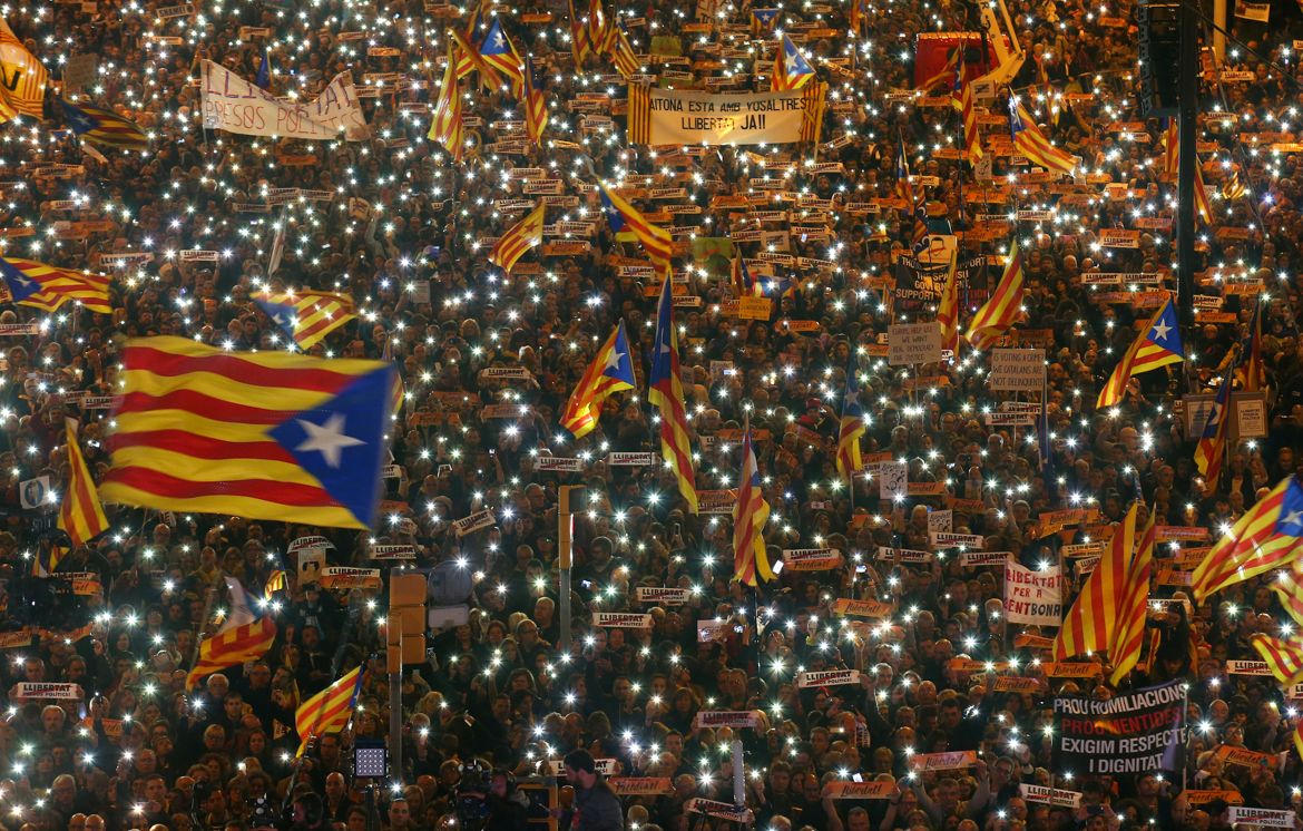 Protesters hold the lights of their mobile phones as they wave Estelada flags during a demonstration called by pro-independence associations asking for the release of jailed Catalan activists and lead