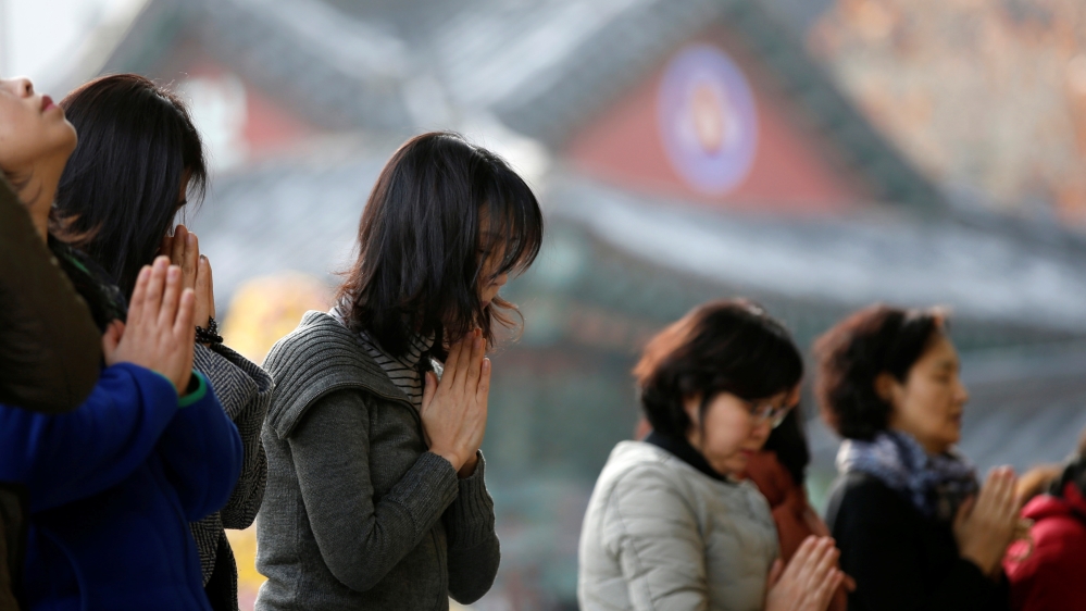Families offer prayers for the success of their children in the college entrance examinations [Kim Kyung-Hoon/Reuters]