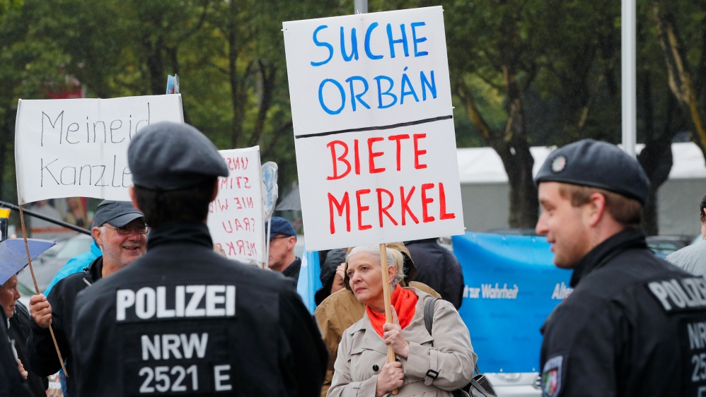 Members of Germany's far-right AfD protest against German Chancellor Angela Merkel in Dortmund, Germany on August 12, 2017. The placard reads, 