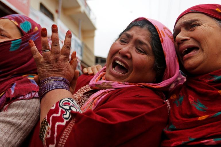 Women mourn as people carry the remains of Mugees Mir during his funeral in Srinagar