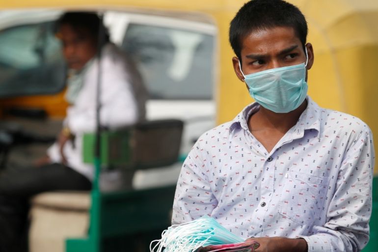 A man sells surgical masks on a smoggy day in New Delhi