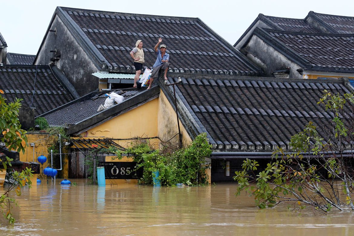 People stand on the roof of their house in Hoi An.